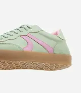 Championes de estilo retro tipo chutera, confeccionados en poliuretano color marrón con detalles en beige en los laterales y el talón. Presentan suela plana de goma color caramelo y cierre mediante cordones.