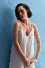 Vestido largo blanco de corte amplio y silueta recta, confeccionado en mezcla de lyocell, viscosa, nylon y lino. Tiene escote en V y breteles finos regulables.