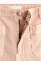 Jean amplio de tiro alto confeccionado en denim de algodón color rosado, con bolsillos frontales de parche y raya marcada al frente y en la espalda.
