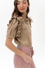 Camisa celeste de lino con cuello mao y mangas cortas abullonadas con volados. Cierre frontal con botones.