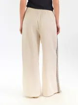 Pantalón ancho de lino color azul marino, de tiro alto, con bordado decorativo en color blanco en los laterales.