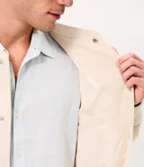 Campera bomber masculina de terciopelo cotelé color beige, con cuello redondo, mangas largas, cierre frontal de botones forrados, bolsillos laterales y terminaciones de elástico en puños y cintura.