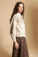 Sweater de tejido jacquard con diseño geométrico en color marrón sobre base beige, de cuello redondo y manga larga con puños ajustados.