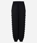 Pantalón balloon de crepé negro, de corte amplio y cintura elástica, con detalles de encaje en los laterales y puños inferiores elastizados.