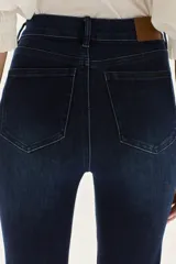 Jean de tiro alto, color azul oscuro, con calce ajustado hasta la rodilla y abertura ancha estilo oxford/flare.