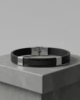 Pulsera de diseño masculino con banda de cuerina negra y placa central de acero con textura geométrica y detalles laterales en acero pulido.