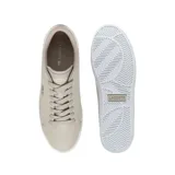 Championes Lacoste modelo Powercourt, color beige con detalles en blanco en el talón y suela. Presenta el logo del cocodrilo bordado en el lateral y cierre con cordones al tono.