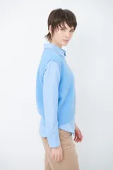 Chaleco de punto sin mangas, color azul, con cuello redondo y diseño de calce holgado.