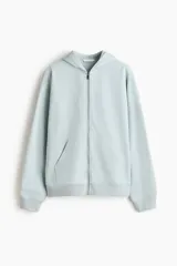 Campera con capucha de felpa color celeste, corte holgado con hombros caídos, cierre frontal y bolsillos delanteros tipo canguro.
