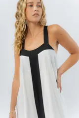 Vestido midi negro con panel frontal blanco, de corte amplio, escote recto y tiras anchas.