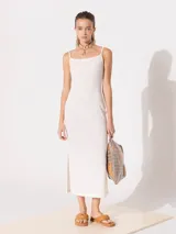 Vestido largo color crudo de punto liso, con breteles finos y escote recto.