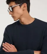 Suéter negro de tejido de punto maquinetado con cuello redondo y manga larga.