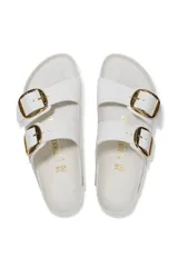 Sandalias Birkenstock Arizona color blanco con hebillas grandes doradas.
