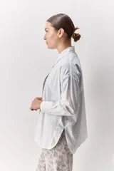 Camisa de algodón de calce relajado con cuello clásico, mangas largas con puños abotonados y cierre frontal con botones.