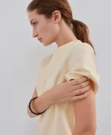 Camiseta de manga corta y cuello redondo color amarillo claro, confeccionada en algodón con ribete elastizado en el cuello.