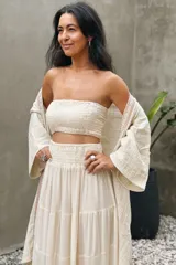 Conjunto compuesto por un top fruncido strapless de algodón con detalle de lurex y una falda larga fluida de talle alto con volantes y cintura fruncida.