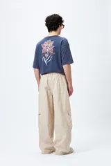 Pantalón cargo color beige, de corte recto y holgado, con cintura elástica y bolsillos laterales con solapa.