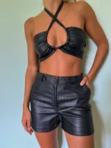 Short de cuero sintético negro con estampado croco, tiro alto y corte ajustado.