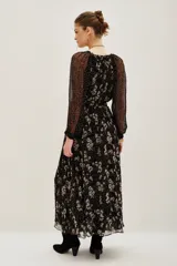 Vestido midi de viscosa con estampado floral y de lunares, cuello en V con lazo ajustable, mangas largas abullonadas con puños elásticos y falda fluida con forro interior.