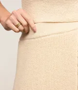 Pollera evasé midi de punto con cintura alta y elástico. Presenta un diseño con traspase delantero.