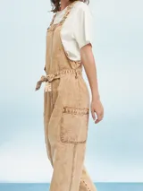 Mono largo de denim celeste con breteles regulables y lazo en la cintura.