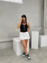 Minifalda blanca de corte cargo con bolsillos laterales con solapa y botón a presión.