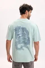 Remera oversize de manga corta en color verde agua, con diseño de dragón azul estampado en la espalda.