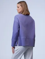 Buzo de jersey color lila con cuello alto y tajos laterales.