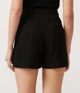 Short negro de sastrería con cintura alta, bolsillos laterales y cierre frontal con botones dorados.