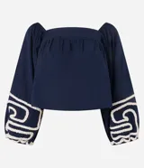 Blusa corta de algodón color azul marino, con escote cuadrado, mangas largas abullonadas y detalle de bordado en cuerda blanca en los puños.