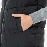 Chaleco largo tipo puffer en color negro, con diseño acolchado, cierre frontal completo y capucha ajustable con cordones. Cuenta con bolsillos laterales y un corte recto hasta la rodilla.