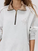 Buzo de algodón con cuello alto y cierre frontal parcial. Presenta bolsillos laterales con cierre y cuello con interior en contraste. Diseño de corte oversize.