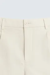 Bermuda de hombre color beige claro, corte regular fit, con pliegues frontales, bolsillos delanteros y bolsillos traseros de doble vivo con botón.