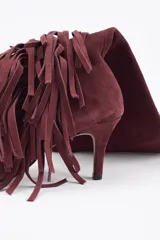 Bota de caña alta confeccionada en cuero vacuno color bordó, con diseño de flecos laterales y taco fino.