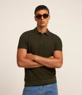 Remera polo blanca de viscosa texturizada con rayas, cuello y puños de mangas cortas en ribana con detalles contrastantes en negro.