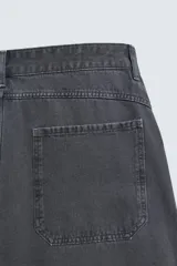 Pantalón wide fit color gris oscuro, confeccionado en tejido ligero de algodón. Cuenta con cinco bolsillos y efecto lavado. Cierre frontal con cremallera y botón.