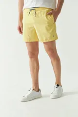 Short de baño liso de corte clásico, con cintura elástica ajustable mediante cordón. Cuenta con dos bolsillos laterales y uno trasero, confeccionado en tejido ligero de secado rápido con logo bordado.