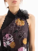 Top halter sin mangas de color negro con estampado floral y bordados, con apliques de flores en 3D en el cuello y tiras colgantes en el lateral.
