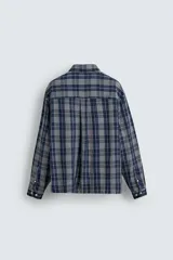 Camisa de corte relajado confeccionada en tejido fluido con mezcla de viscosa y acetato. Presenta un diseño a cuadros, cuello solapa, manga larga con puños abotonados, bolsillo plastrón en el pecho y cierre frontal con botones.