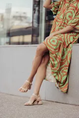 Sandalias plateadas con tira ancha sobre los dedos, tira fina con hebilla al tobillo y taco cuadrado bajo.