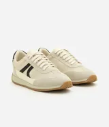 Championes estilo runner de diseño vintage, confeccionados en una combinación de tejido de malla respirable, recortes de gamuza y detalles en material sintético. Presentan cierre con cordones, detalle lateral aplicado en contraste y suela de goma plana con base color caramelo.