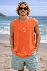 Musculosa color naranja con efecto acid wash y un pequeño estampado frontal en blanco que representa una figura humanoide con un hongo en la cabeza.