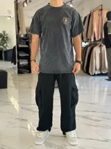 Remera oversize color negro con efecto gastado (acid wash), manga corta, y gran estampado en la espalda de una calavera con la inscripción "Mushkana Born to Chill".