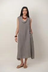 Vestido midi de lino color verde militar, sin mangas, con escote buche y bolsillos laterales, de corte relajado y fluido.