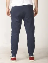 Pantalón jogging de corte slim, con puños elastizados, cintura con cordón ajustable, cierres laterales engomados y bolsillo tipo parche lateral.