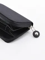 Billetera negra con cierre de cremallera y logo circular en el frente.