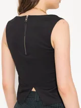 Top negro de punto tipo sastrero, sin mangas y con escote cavado. Interior forrado en microfibra y acceso mediante cierre metálico.