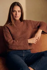 Polera de lana color marrón, con cuello alto, diseño acanalado y corte oversize con mangas anchas.