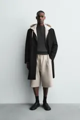 Bermuda de corte oversize confeccionada en tejido técnico compacto con elasticidad. Presenta cintura elástica ajustable con cordón, pinzas en el delantero y la espalda, y bolsillos laterales.