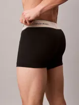 Pack de tres bóxers tipo trunk de color negro, confeccionados en algodón con elastano. Presentan una cintura elástica ancha en color blanco con el logo de la marca estampado en repetidas ocasiones.